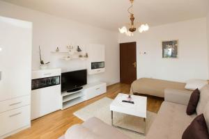 a living room with a couch and a tv at Apartmani Vera in Crikvenica