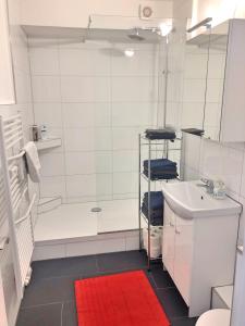 een badkamer met een douche en een rood tapijt bij FeWo Altstadt - Mitten im Herz Goslar in Goslar