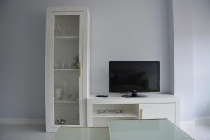 sala de estar con TV y armario blanco en Apartamento Sira en Sanxenxo