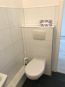 een witte badkamer met een toilet en een wastafel bij FeWo Altstadt - Mitten im Herz Goslar in Goslar