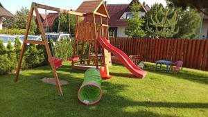 um parque infantil com um escorrega e um baloiço num quintal em Villa Tatran em Stará Lesná