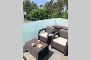 a patio with a table and chairs on a balcony at Rewal Apartament "PANORAMA" in Rewal