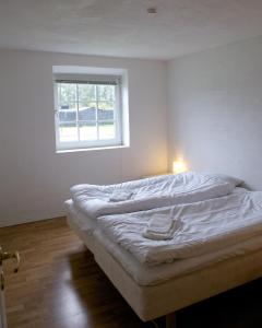 een bed in een kamer met een raam bij Nymarksminde in Vodskov