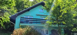 a blue house surrounded by trees at Chata Zuzana in Bítov