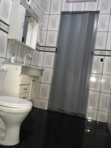 uma casa de banho com um WC branco e um lavatório. em Quarto INDIVIDUAL Casa Super Aconchegante WIFI 350 MEGA em Osasco