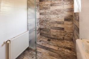 a bathroom with a shower with wooden walls at Apartments & Rooms Strčić Petra in Krk