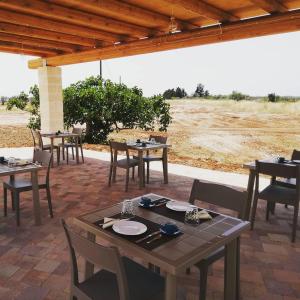 a patio with tables and chairs in a field at Armonia Galeta in Nardò