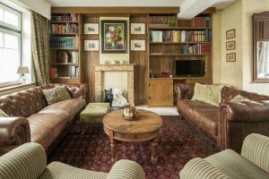 a living room with leather couches and a fireplace at Tilia in Damme