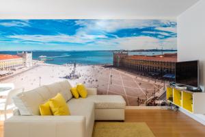 een woonkamer met een witte bank en uitzicht op het strand bij Vita Portucale ! Downtown Premium Apartment with Parking Garage in Lissabon