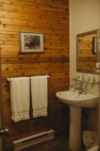 a bathroom with a white sink and a mirror and towels at Carriage House Inn Four and a Half Stars in Grand Falls -Windsor