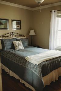 a large bed in a bedroom with a window at Carriage House Inn Four and a Half Stars in Grand Falls -Windsor