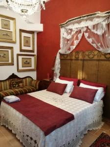 Schlafzimmer mit einem großen Bett mit roten Wänden in der Unterkunft Il Trullo del Cadetto in Francavilla Fontana