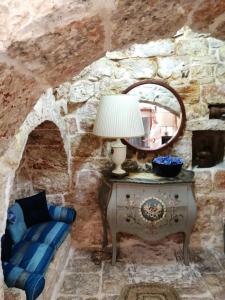 a stone walled room with a table and a mirror at Il Trullo del Cadetto in Francavilla Fontana