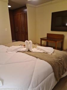 a bed with two swans made to look like towels at Alpenhaus Gramado Flat Temporada in Gramado