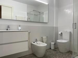 ein Badezimmer mit Waschbecken, Toilette und Spiegel in der Unterkunft Apartamento Padron Centro P8 by URent in Padrón + 12 Fotos