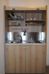 a kitchen with a sink and a stainless steel cabinet at Hotel Castelli in Kallithea Halkidikis