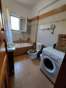 a bathroom with a washing machine and a toilet at Good Vibes Villa in Eresos