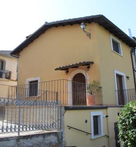a yellow house with a balcony and a gate at Il Pagliarello di Villa San Giovanni in San Demetrio neʼ Vestini