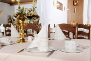 einen Tisch mit einem weißen Tischtuch und Servietten in der Unterkunft Hotel Alte Post Garni in Ginsheim-Gustavsburg