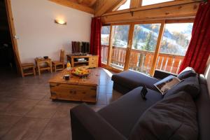 a living room with a couch and a table at Chalet Le Peak in Valloire