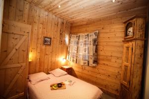 1 dormitorio con 1 cama en una habitación de madera en Chalet Le Peak, en Valloire