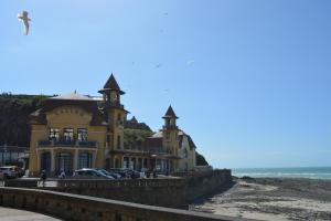 a yellow building on the beach next to the ocean at Granville plage normandie mont saint Michel in Granville