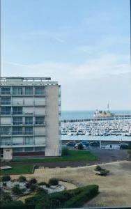 um grande edifício em frente a uma marina com barcos em Studio Meublé Vue Mer em Le Havre