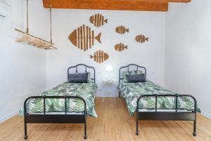 duas camas num quarto com peixe na parede em House in the Historic Center- Portimão em Portimão