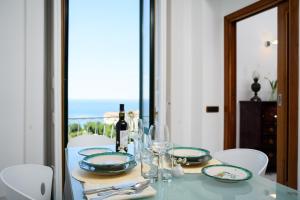 una mesa de comedor con una botella de vino y copas en Amalfi Coast Family Luxury Suite, en Vietri