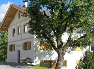 Una casa blanca con un árbol delante. en Appartment Kirch Neuhaus, en Laion