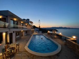 a large swimming pool on the side of a house at Ostria Apartments in Agios Nikolaos