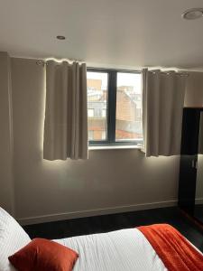 a bedroom with a bed and a window with curtains at The Whyte House in Sheffield