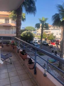 un balcone con palme e una strada di Magnifique emplacement pour ce joli f3 a Cavalaire-sur-Mer