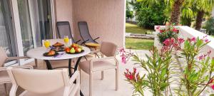 - une table avec une assiette de nourriture sur la terrasse dans l'établissement Apartment Garden & Sea, à Volosko