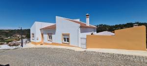 a white house with a yellow and white wall at Casa dos Avós in Odeceixe