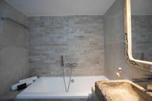 y baño con bañera y espejo. en Villa Jakie, en Mykonos ciudad