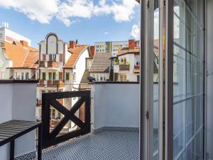 una puerta abierta a un balcón con vistas a los edificios en VacationClub – Dubois 16C Apartament 11 en Kołobrzeg