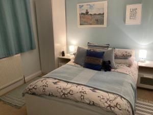 un dormitorio con una cama con un gato sentado en ella en Rural Farmhouse, en Poughill