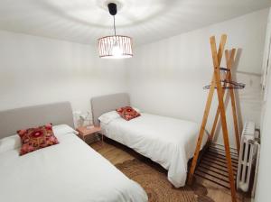 una camera da letto con due letti e un lampadario di FLOR DE LIS a Sant Hilari Sacalm