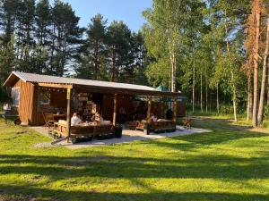 a group of people sitting in a shed in a field at Metsaääre Accommodation in Uulu