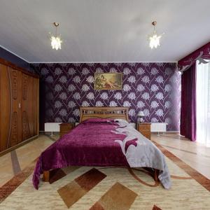 a bedroom with a purple bed with a purple blanket at Morshynska Vezha Hotel in Morshin