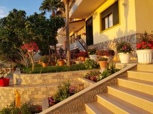 a house with flowers in pots on the stairs at Villa Meminaj Vlore Sea view and Garden Vlore in Vlorë