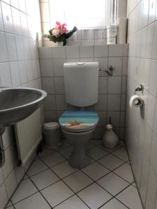 uma casa de banho com um WC com uma estrela do mar no assento em Pension „La Rose“ em Norden