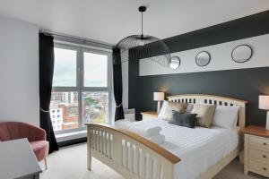 um quarto com uma cama branca e uma grande janela em The Marina Penthouse em Ipswich