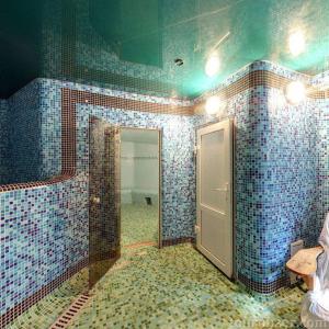 baño con paredes de azulejos azules y puerta en Morshynska Vezha Hotel, en Morshyn