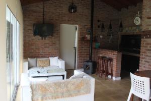 a living room with a white couch and a brick wall at Paraiso Encontrado in Benavídez