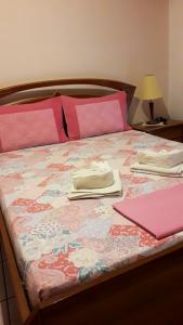 uma cama com lençóis cor-de-rosa e almofadas cor-de-rosa em Antonioy Apartment Metewra em Kalabaka