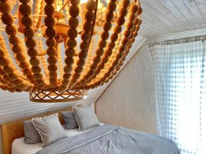 a bedroom with a bed and a chandelier at Apartmenthaus Lütt Meer in Ludorf