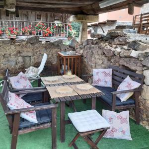 una mesa de madera y sillas en un patio en Al Alba Alojamiento Rural, en Illas