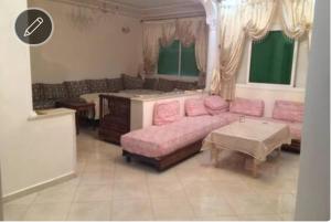 a living room with a pink couch and a table at Appart sur Fes in Fez